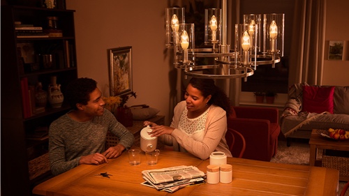 Dos personas sentadas en el sofá de casa disfrutando de una luz LED de gran calidad